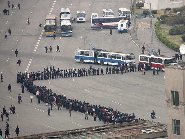 Menschen stehen in einer Schlange für den Bus